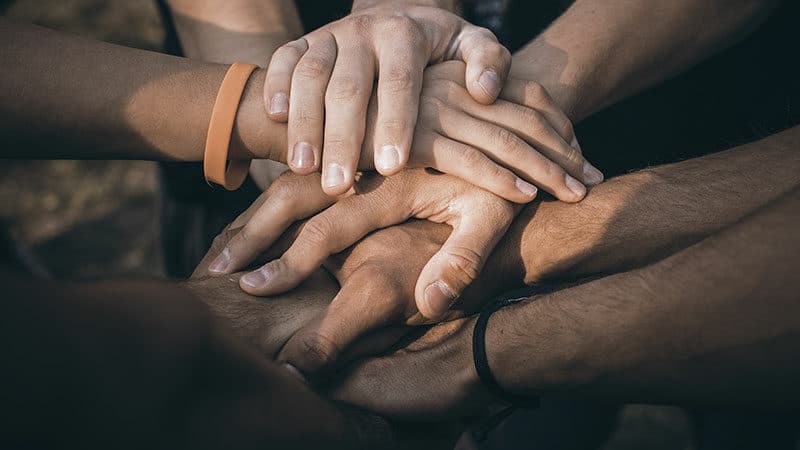 stacked hands representing community support